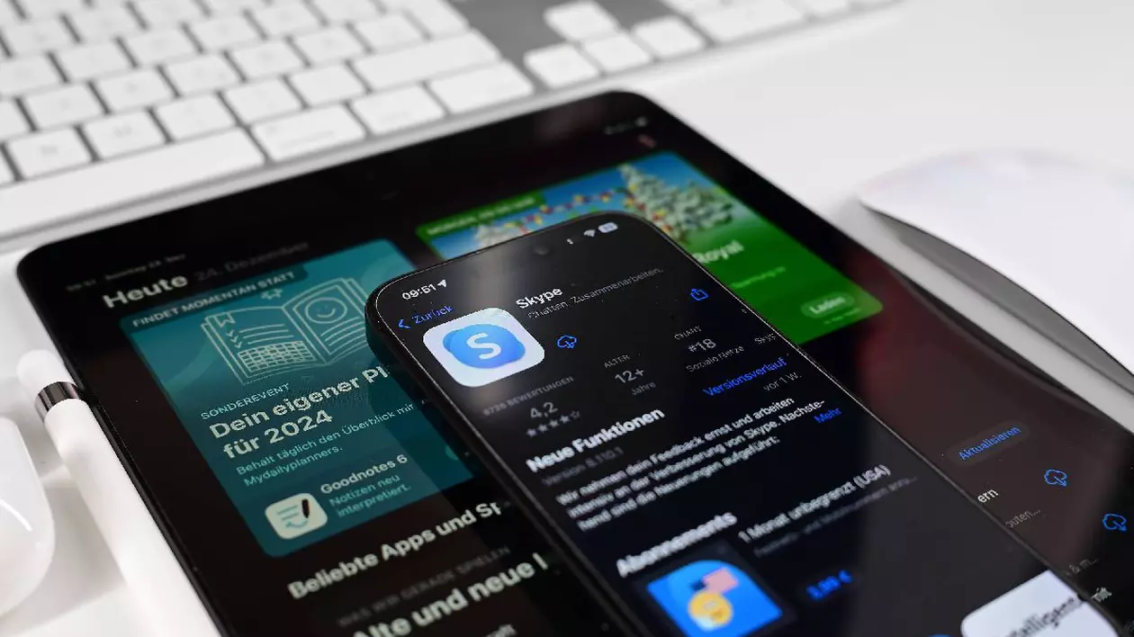 Aplicația Microsoft Skype, deschisă pe un telefon, care este așezat la rândul lui deasupra unei tablete pe care sunt deschise știri.