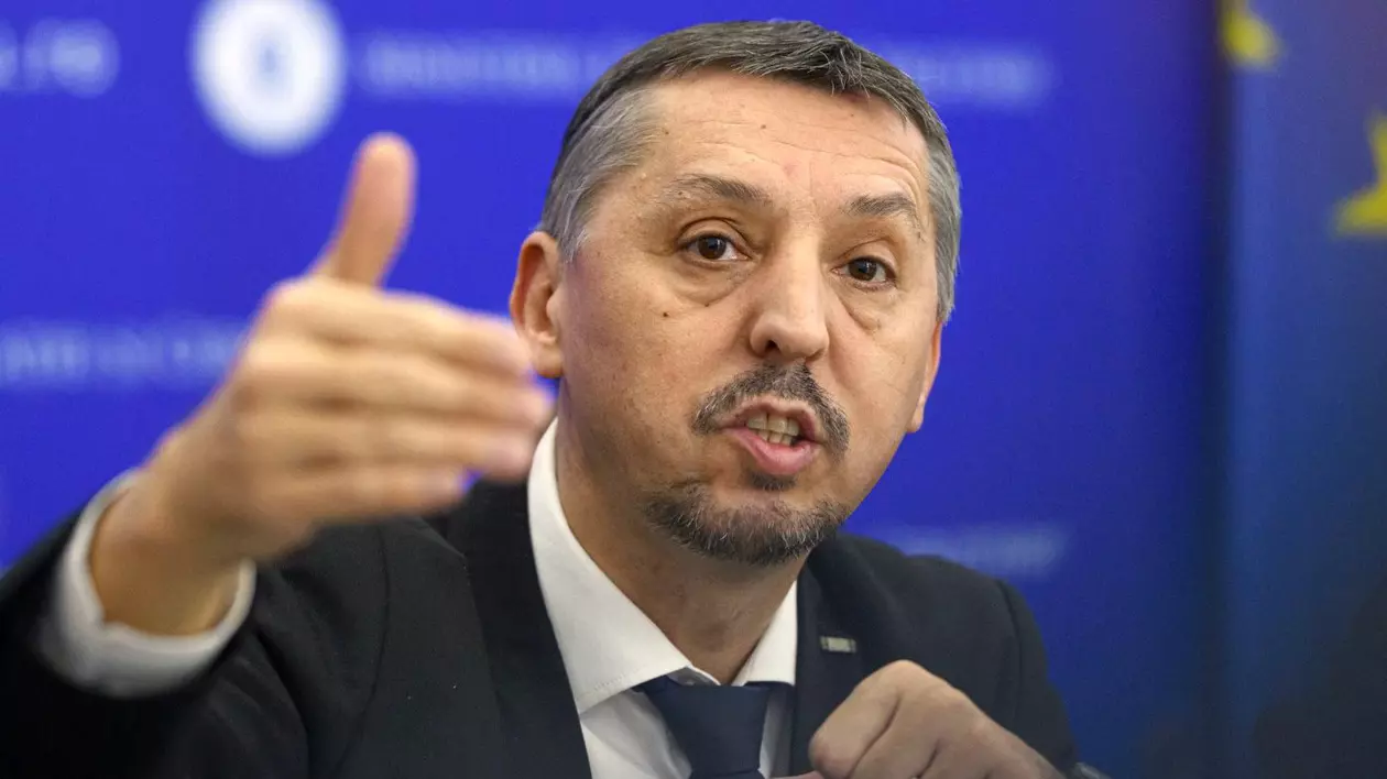 Daniel David, în cadrul unei conferințe de presă, cu mâna dreaptă ridicată