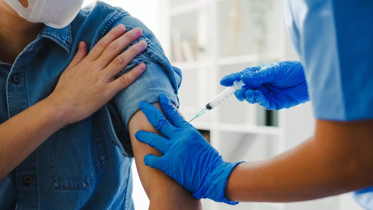 o asistentă medicală administrează un vaccin unui pacient