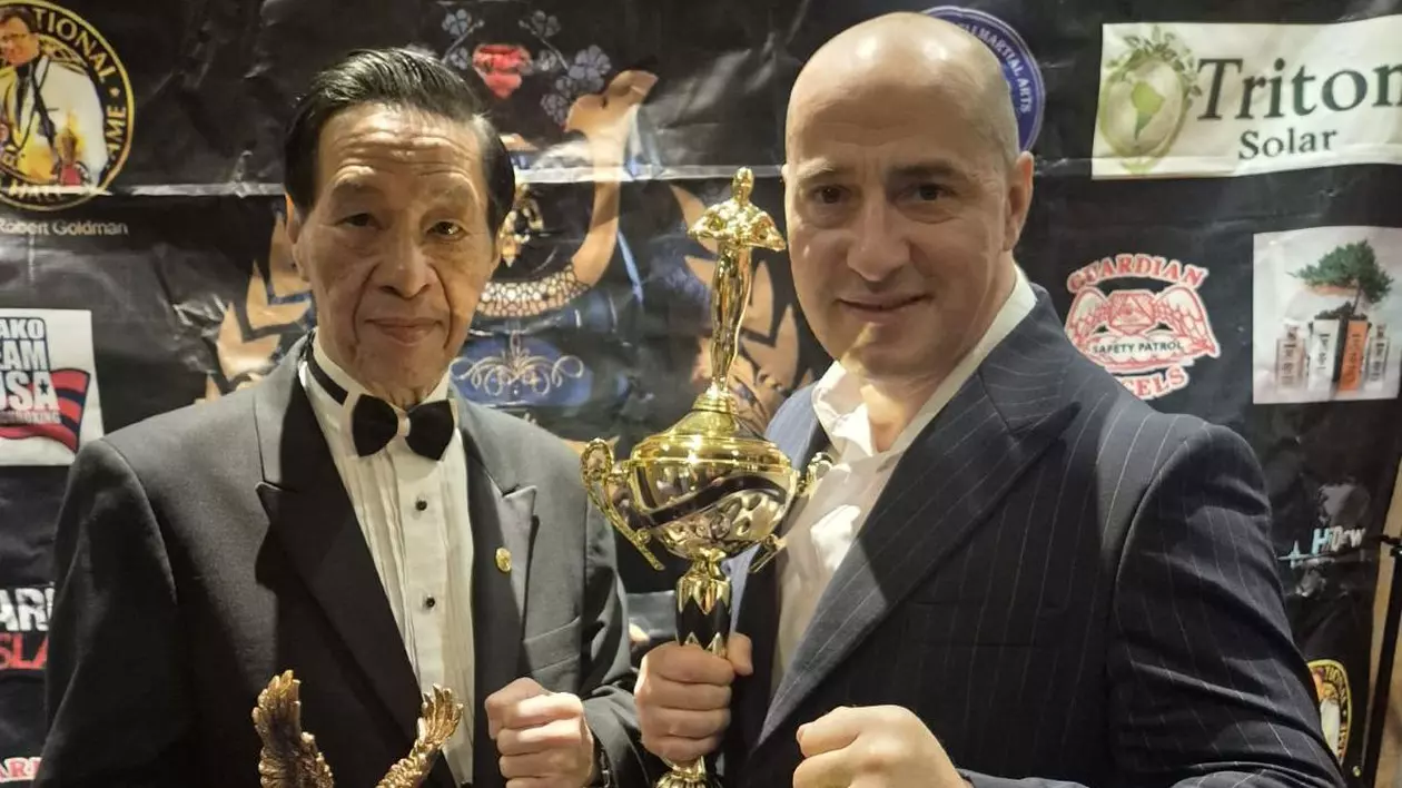 Ovidiu Sfetcu, alături de unul dintre organizatori, după ce a fost premiat. În mână ține trofeul pe care l-a câștigat