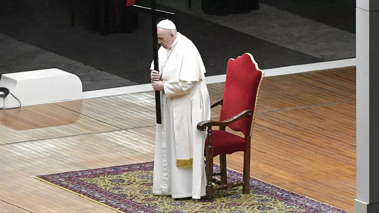 Papa Francisc în depărtare, se asează pe scaun în timpul unei procesiuni în Piața Sfântul Petru