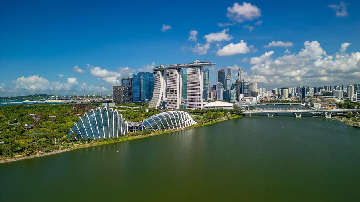 Clădiri zgârie-nori din Singapore, pe malul unei apei.