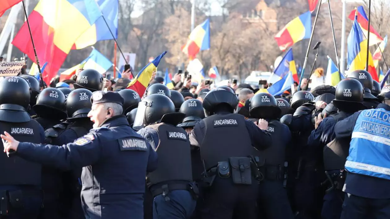 oameni in timpul unui protest tinuti de jandarmi in timp ce au daramat gardurile limita