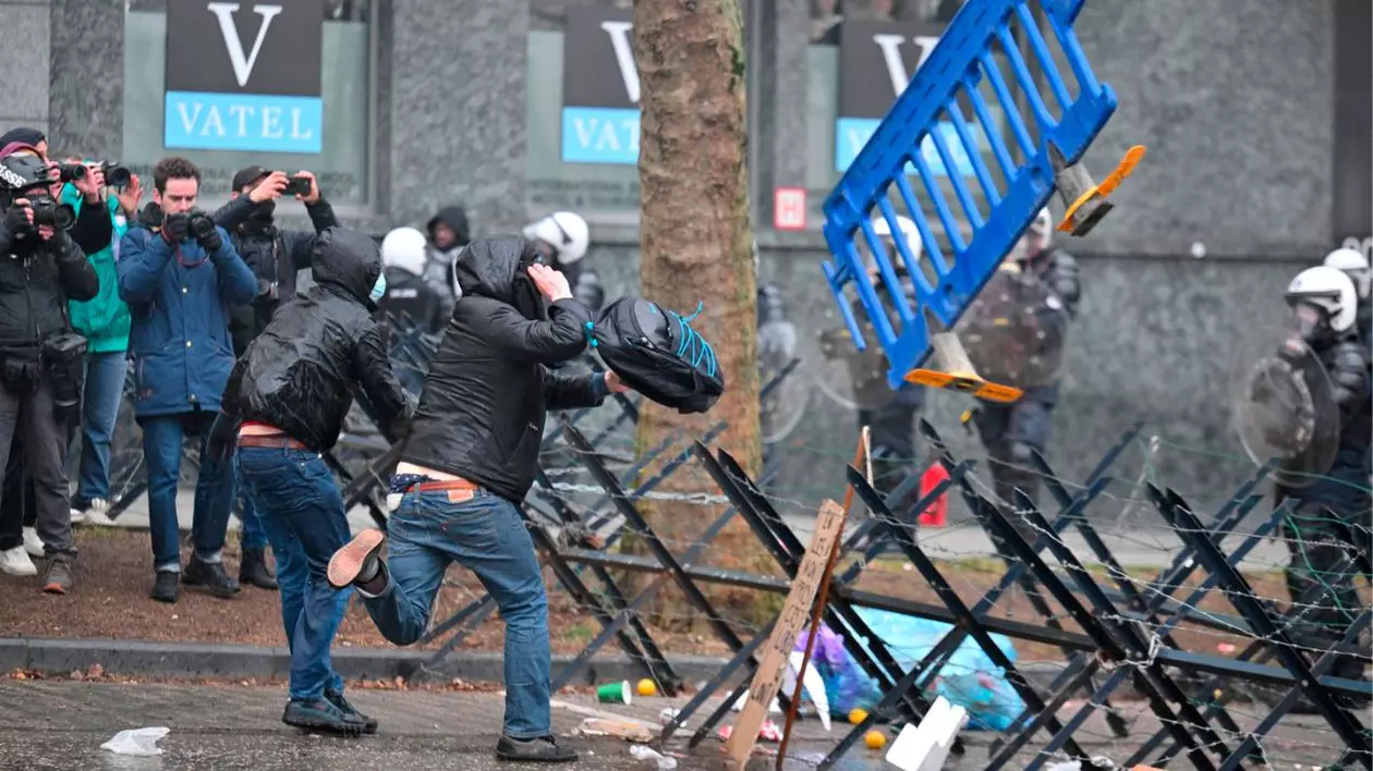 Protestatarii aruncă cu o barieră de plastic în polițiști în timpul protestelor împotriva planului noului guvern de a reforma sistemele speciale de pensii, la Bruxelles, 13 februarie 2025