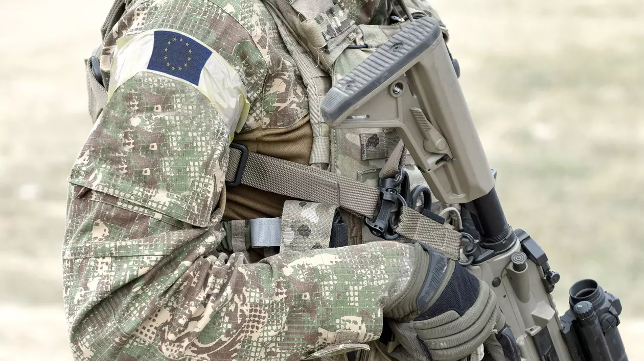 Soldat cu pușcă de asalt și steagul Europei în uniformă militară. Imagine cu caracter ilustrativ Foto: Shutterstock