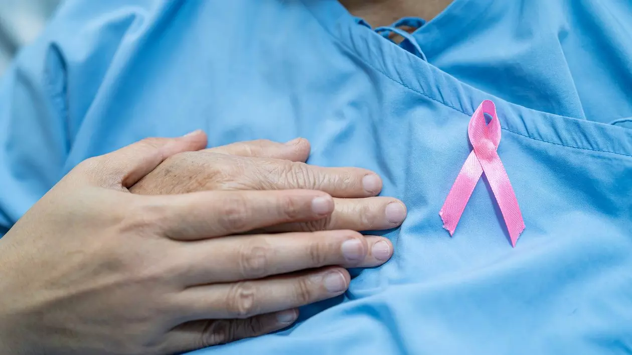 Un pacient cu o funda roz, care semnifică lupta impotriva cancerului de san