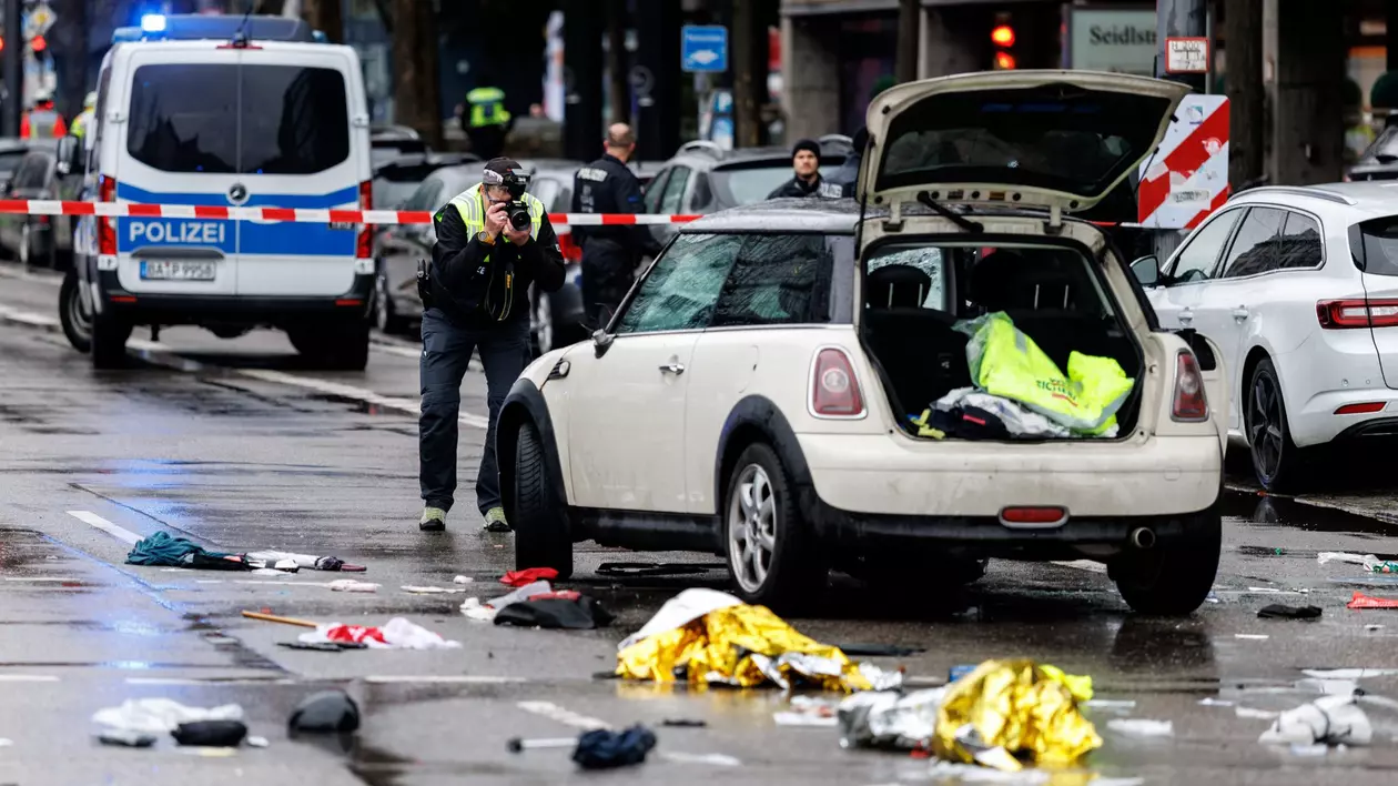Un vehicul a intrat într-un grup de oameni în centrul orașului München. Un ofițer de poliție fotografiază o mașină la fața locului. Foto: DPA /via AFP