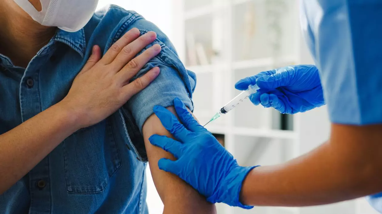 medic care administrează un vaccin în brațul unui pacient
