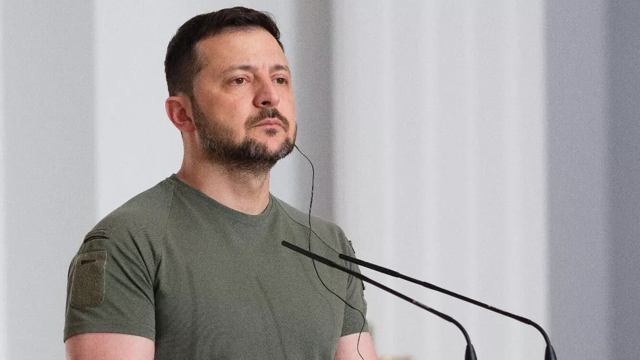 Liderul ucrainean Volodimir Zelenski, îmbrăcat într-un tricou verde militar, în fața unor microfoane