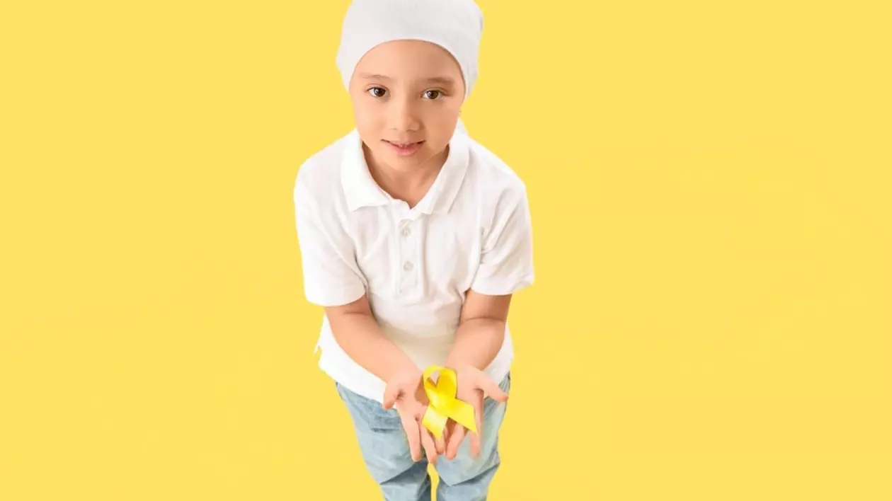 Fetiță după chimioterapie cu panglică galbenă pe fundal colorat. Conceptul de conștientizare a cancerului în copilărie, Sursă foto: Profimedia