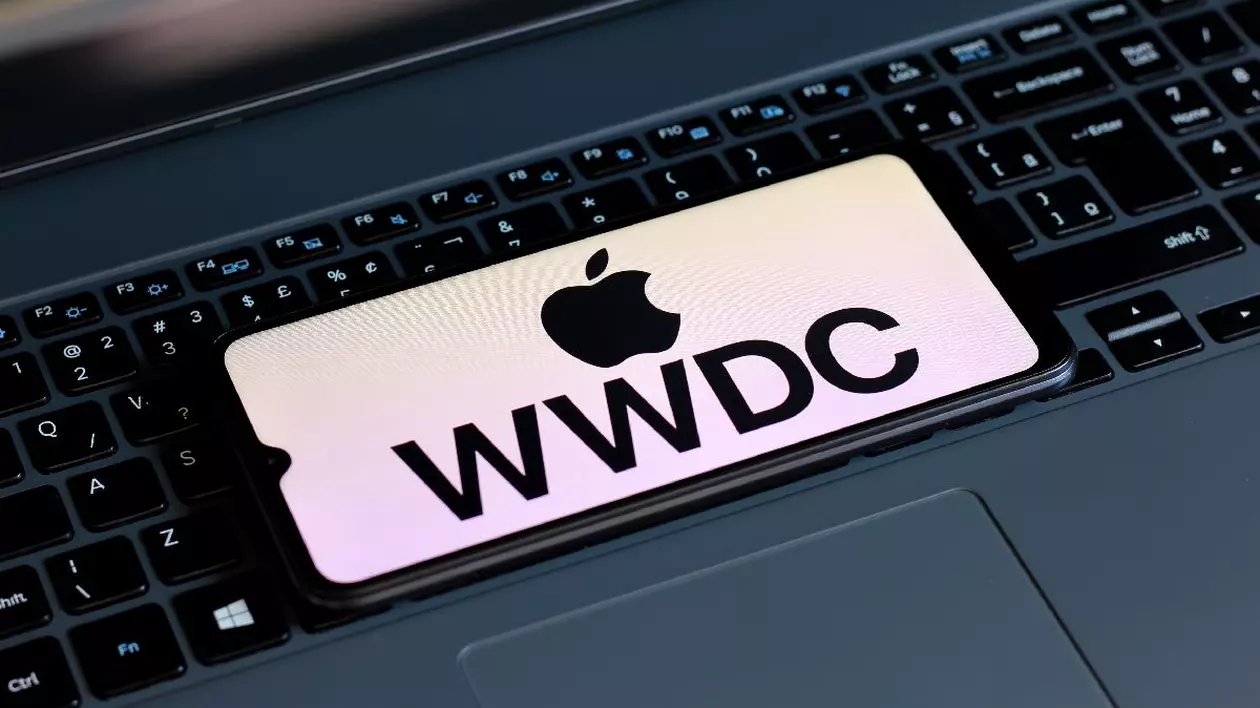 Logoul Apple WWDC, pe un ecran al unui smartphone așezat pe o tastatură de laptop.