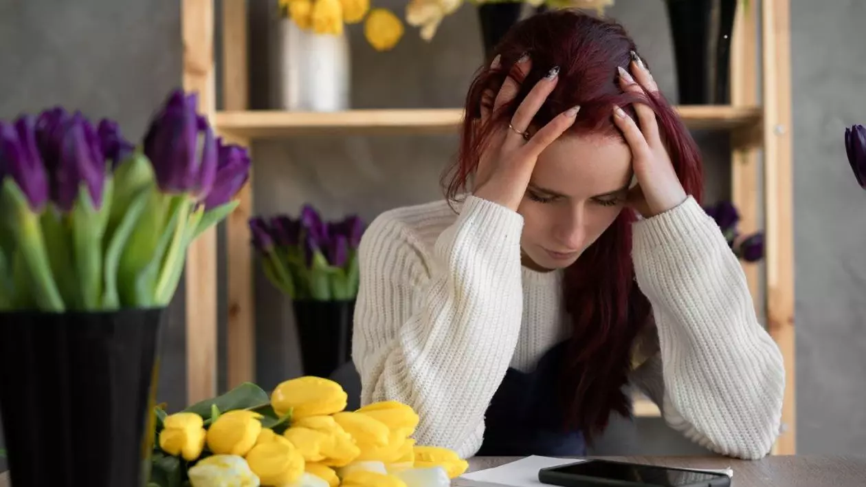 Obosită, deprimată, plictisită femeie caucaziană, cu flori pe masă Foto: Profimedia Images