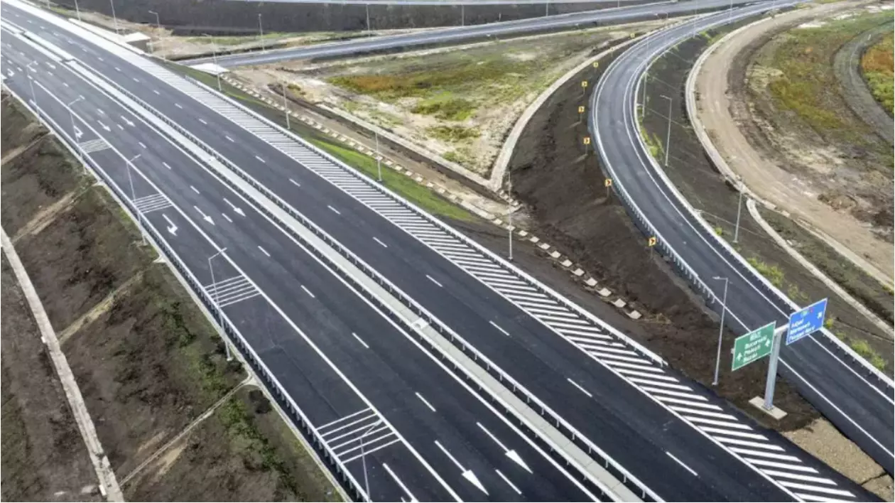 Imaginea prezintă o autostradă cu mai multe benzi de circulație, separatoare de sensuri și marcaje rutiere