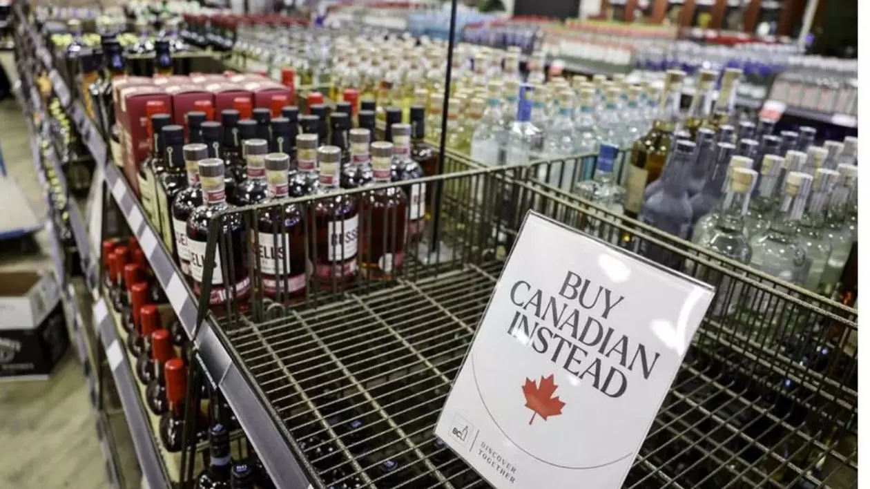 Raft cu sticle într-un magazin din Canada cu un indemn să fie cumpărate produse canadiene în locul celor americane.