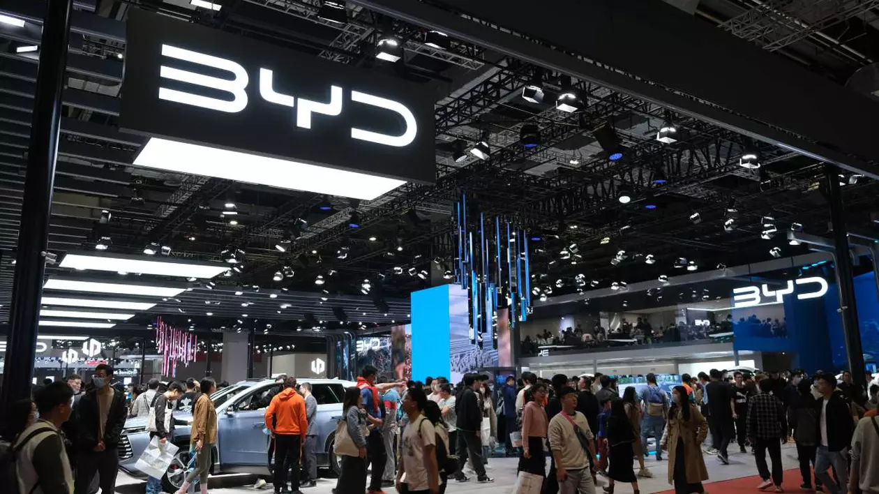 showroom masini electrice byd china. oameni care sunt in miscare sau care studiaza parti ale masiniilor