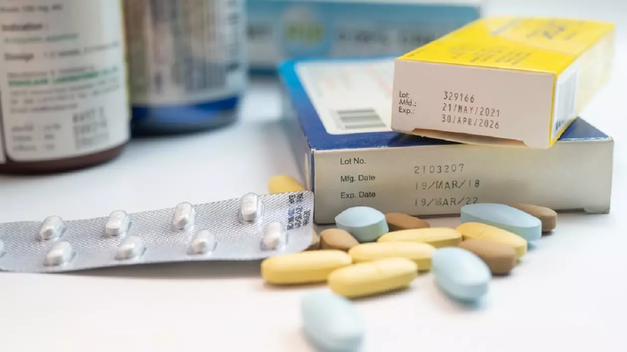 Mai multe cutii si borcane cu medicamente expirate asezate pe o masa alba