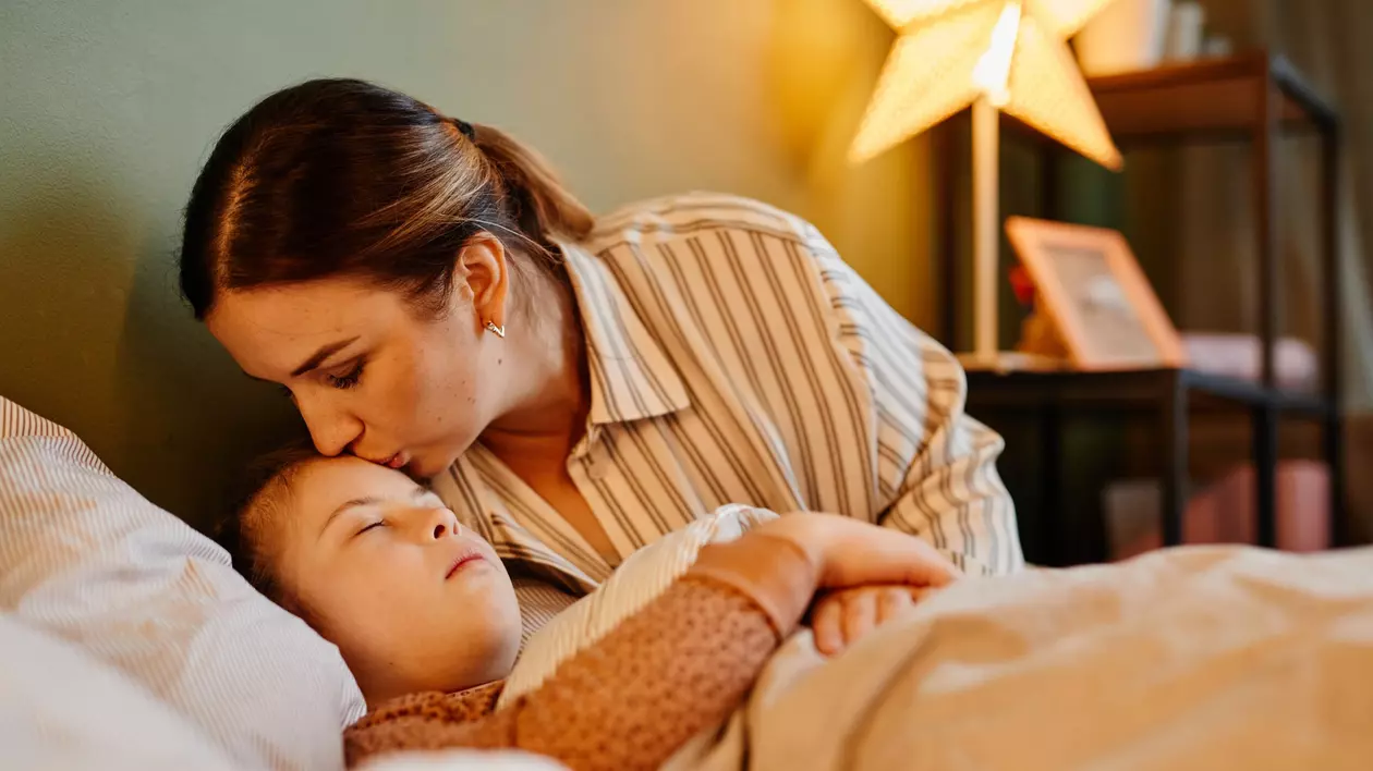 O mama isi saruta fetita care doarme