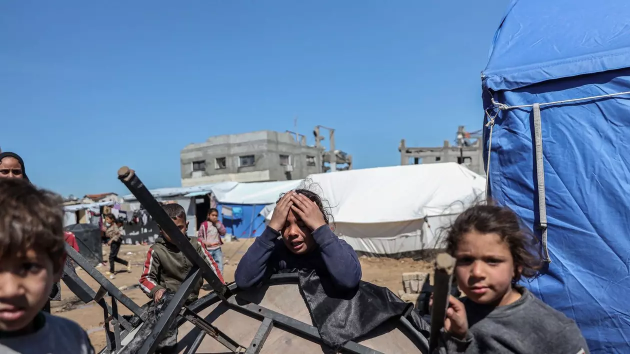 Copii în fața unor adăposturi temporare din Fâșia Gaza Foto: Profimedia