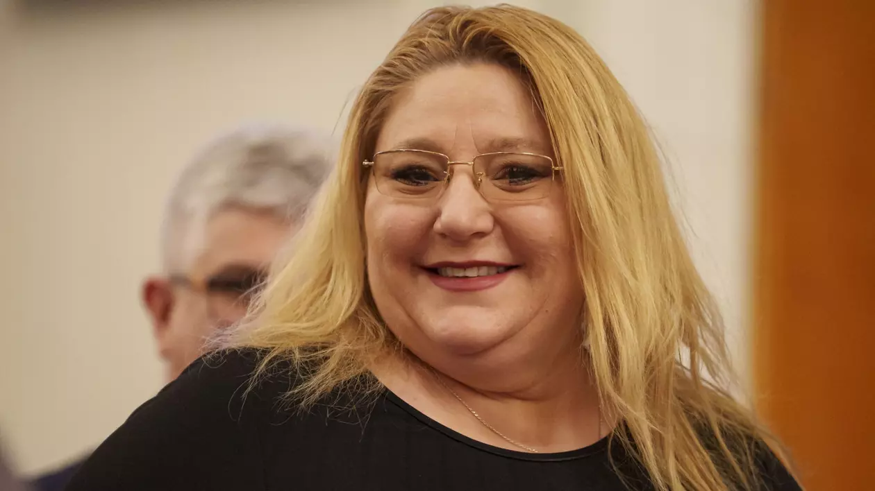 Diana Șoșoacă, îmbrăcată într-o bluză neagră, surprinsă în timp ce zâmbește.