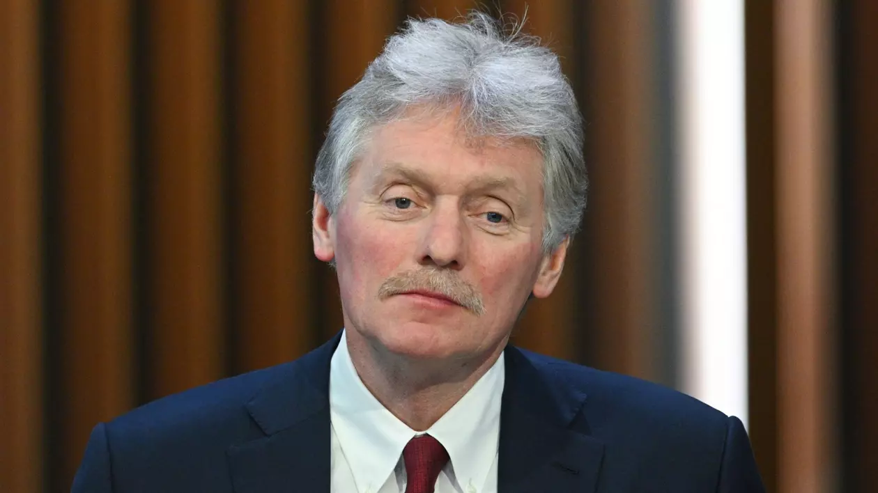 Dmitri Peskov poartă o cravată roșie, o cămașă albă, peste care a asortat un sacou albastru închis
