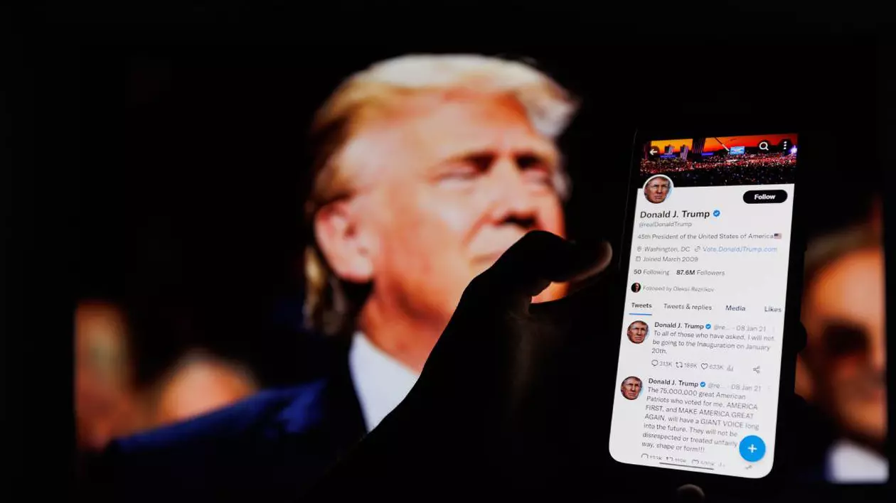 mana unei persoane care tine telefonul deschis pe X unde este deschis contul lui donald trump, pe fundal o fotografie cu donald trump