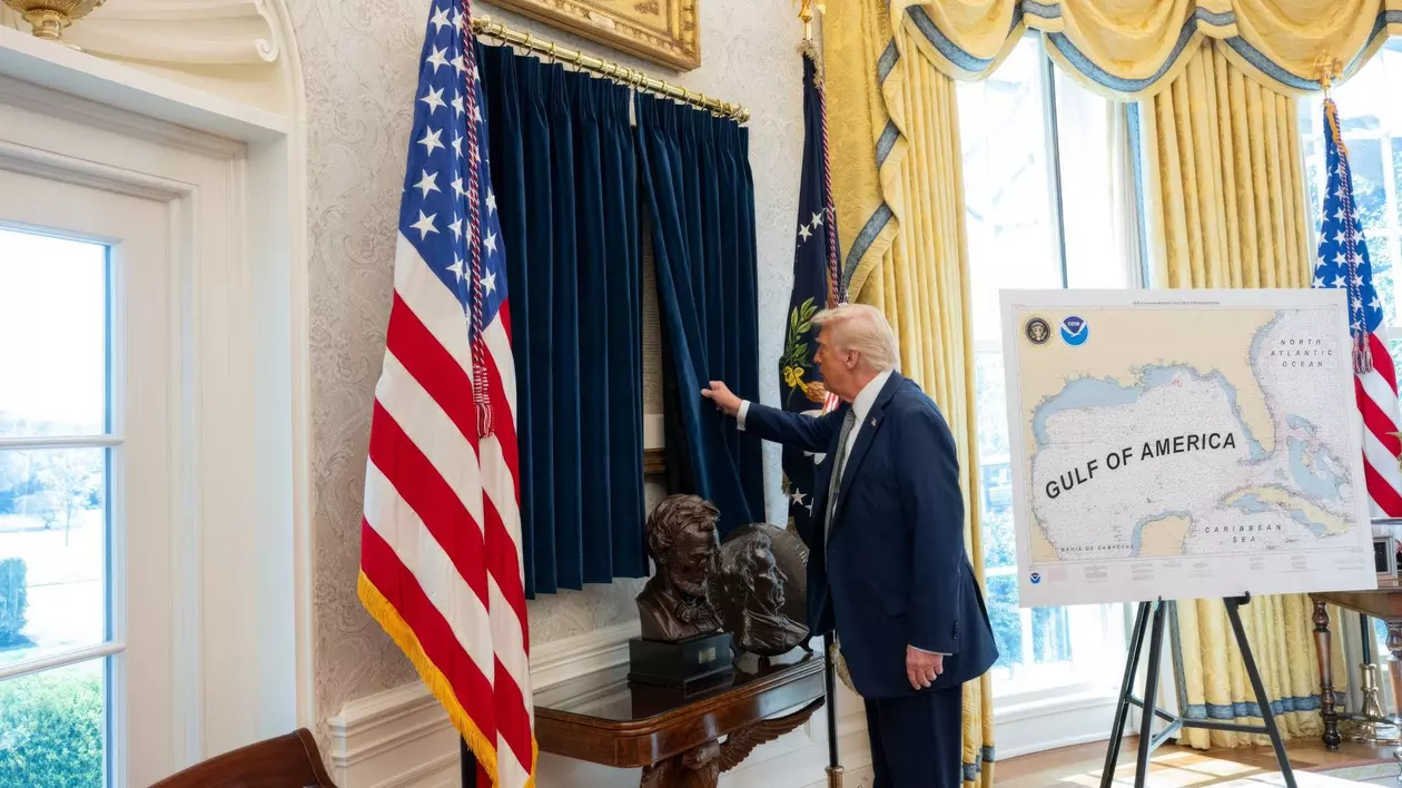 Donald Trump surprins în timp ce dă la o parte perdelele care protejează o copie a Declarației de Independență pe care a instalat-o în Biroul Oval de la Casa Albă.