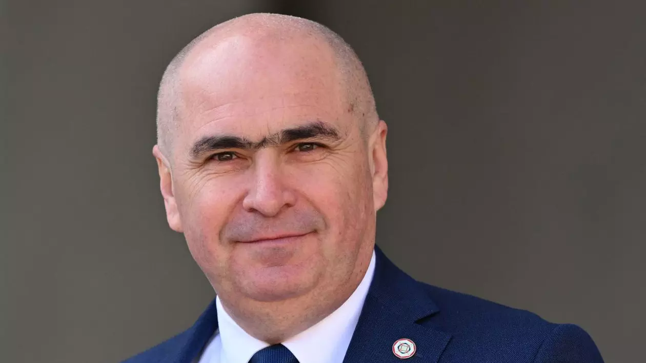 Ilie Bolojan, președintele interimar al României, în prim plan, îmbrăcat în costum, cravată și cămașă albă
