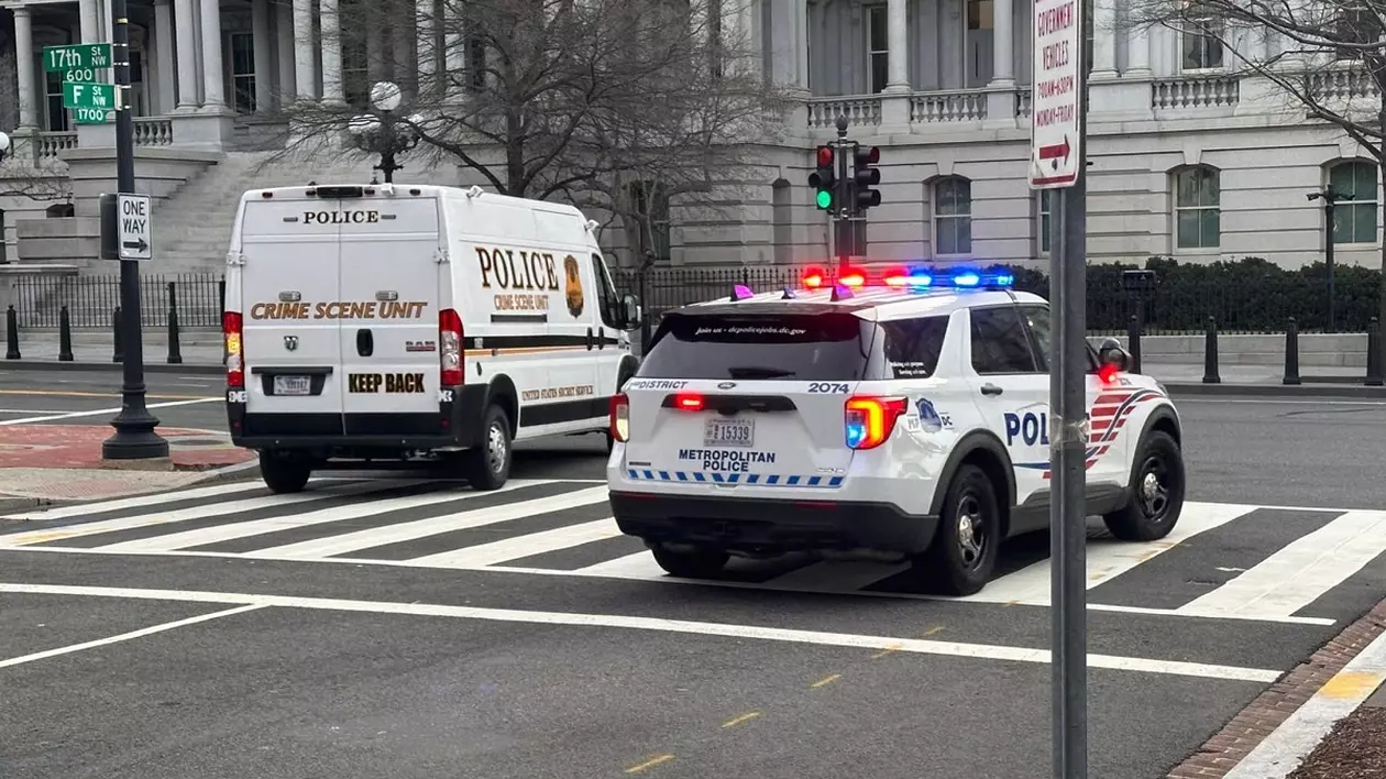 Mașini de poliție, una dintre ele cu girofarul aprins, pe un belevard închis circulației din Washington DC