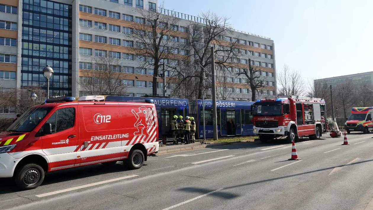 Ambulanțe, o mașină de pompieri pe o șosea și un grup de pompieri