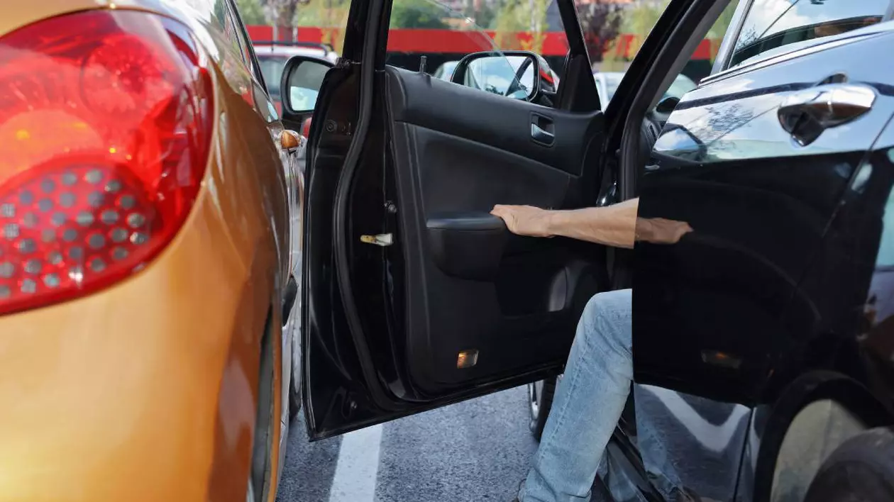 doua masini parcate una langa alta, din masina din dreapta iese un sofer, iar portiera se apropie mult de masina de langa