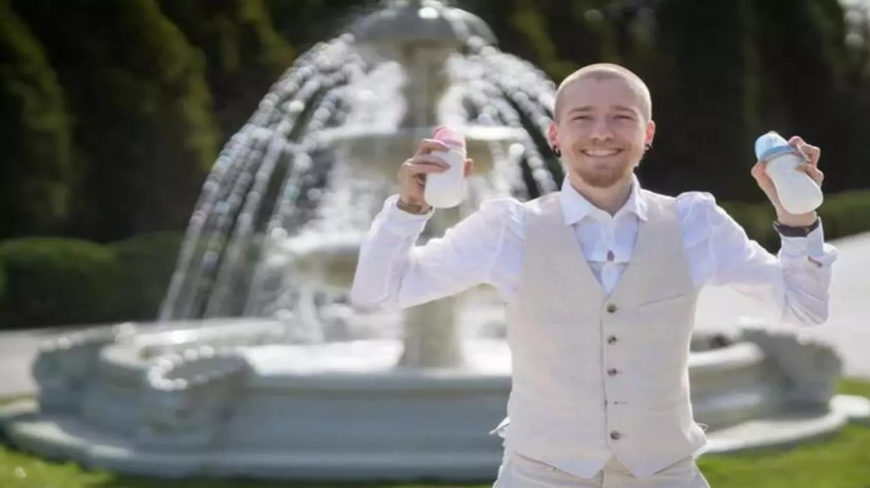 Maxim Cerniavski îmbrăcat în costum cu doua biberoane in mana