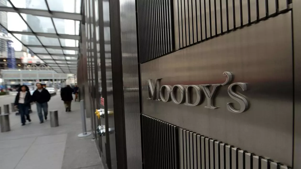 Sediul companiei Moody's și sigla în dreapta, iar în stânga sunt niște oameni care merg pe stradă