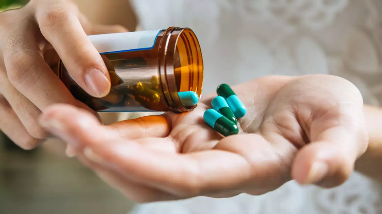 o femeie care toarnă pastilele în palmă dintr-o sticlă cu medicamente