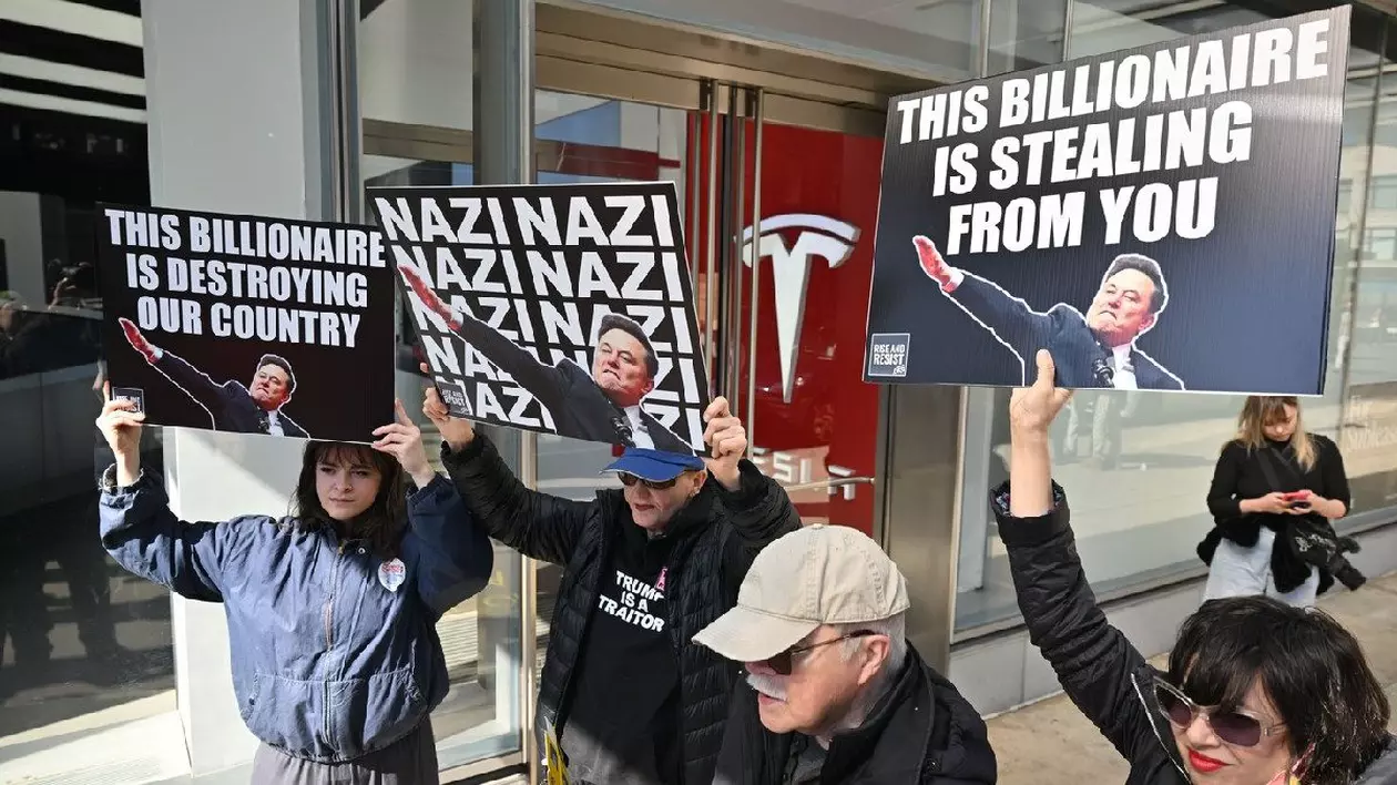 Oamenii participă la protestul „Tesla Takedown NYC - Pull the Plug on Elon” în fața Tesla Meatpacking pe 1 martie 2025 în New York City