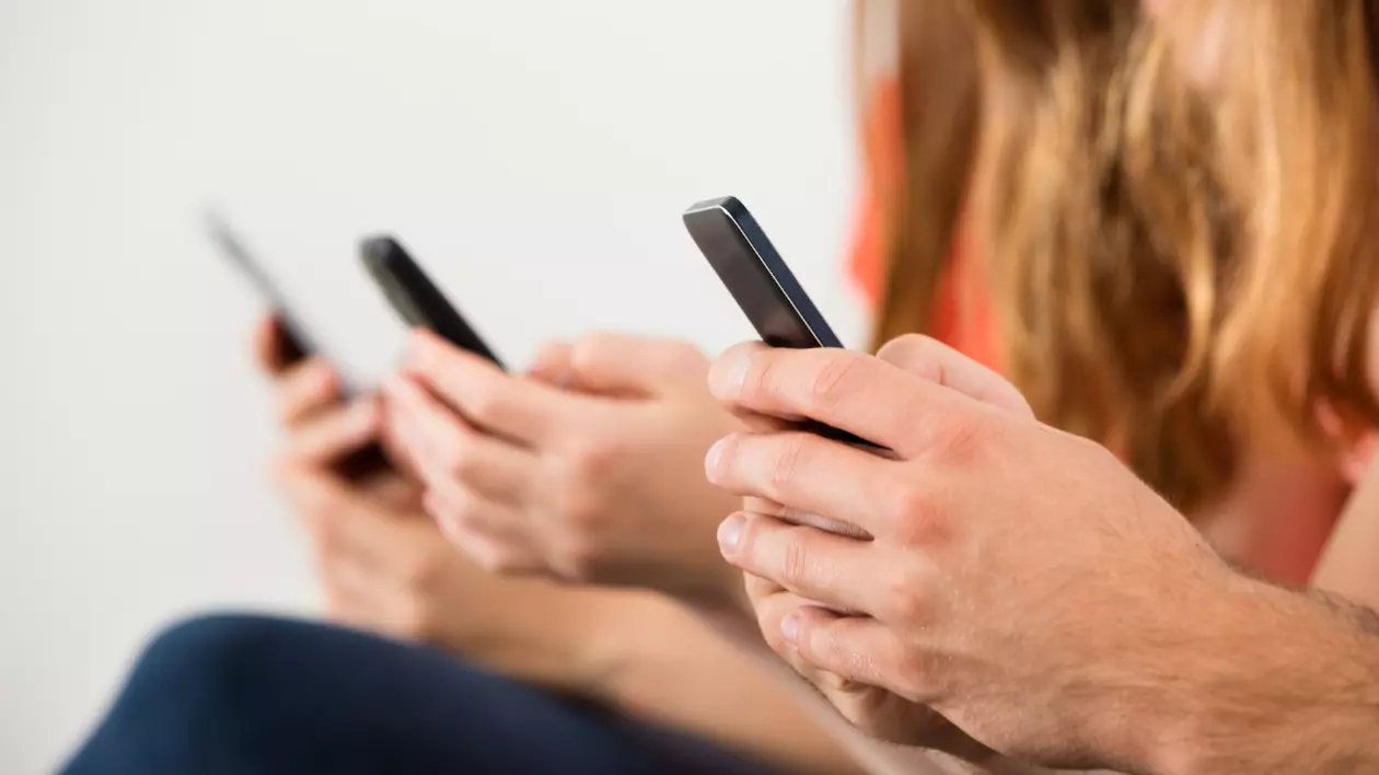Trei oameni care stau cu telefoanele în mână
