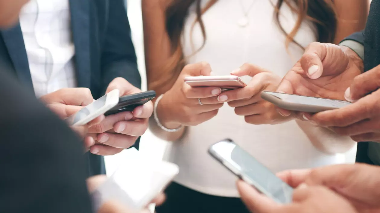 Oameni care stau cu telefoanele în mână
