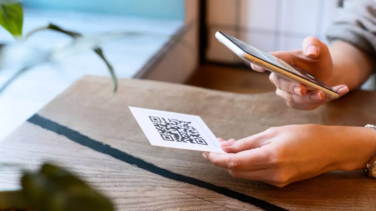 femeie care scanează un cod QR cu telefonul