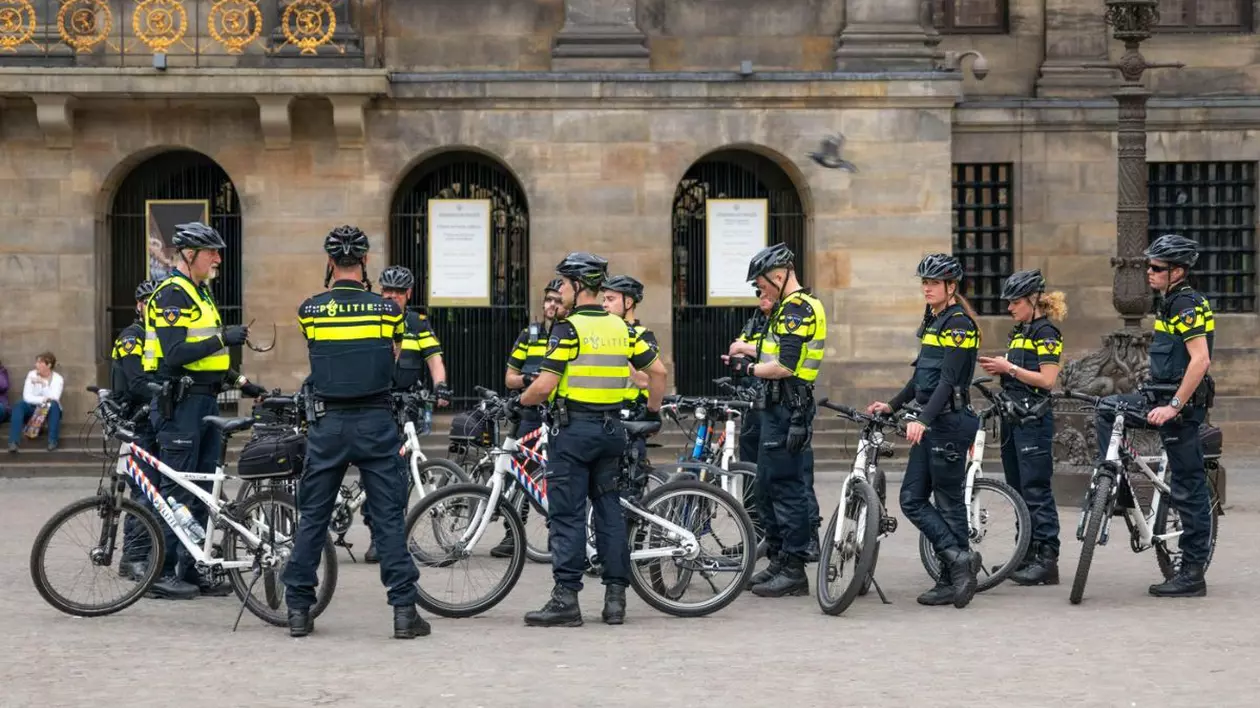 Polițiștii în uniformă, pe biciclete și cu căști, mențin ordinea.
