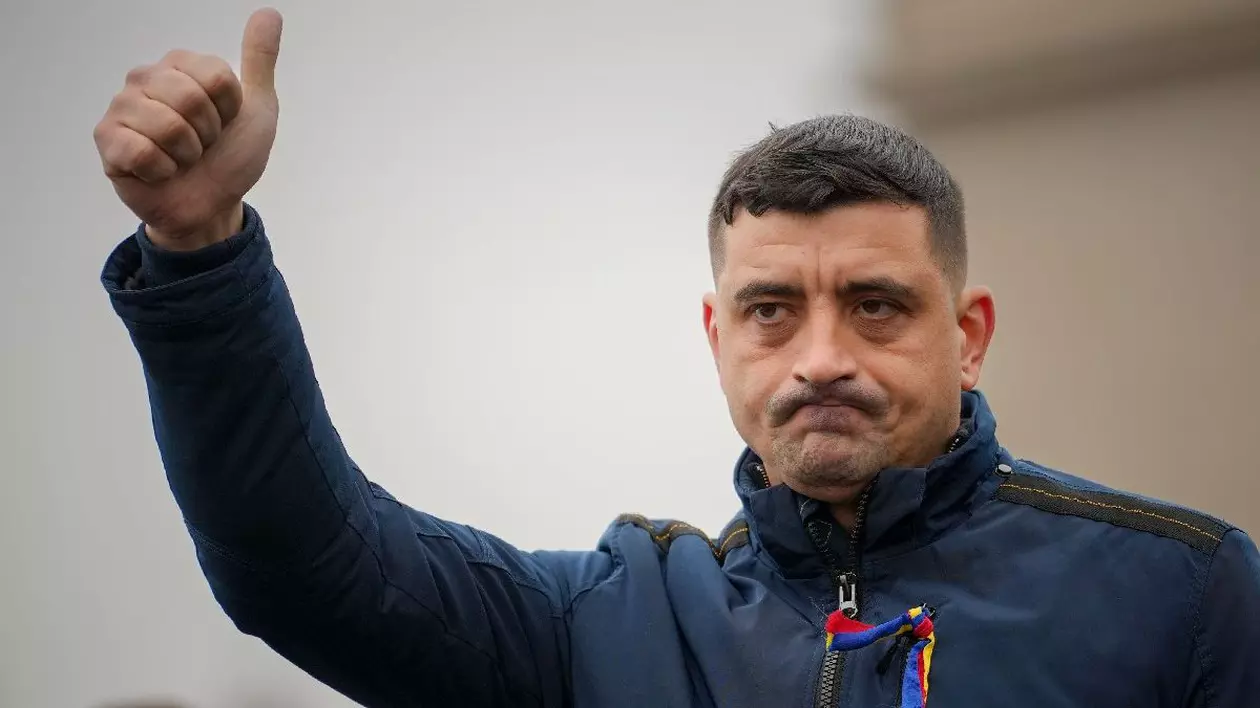 George Simion, liderul AUR, îmbrăcat în geacă albastră, cu un tricolor în piept, cu mâna dreaptă ridicată