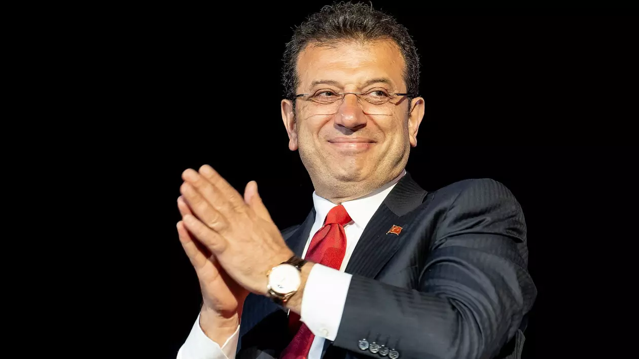 Primarul municipalității metropolitane din Istanbul, Ekrem Imamoglu, aplaudă și este fotografiat pe un fundal negru