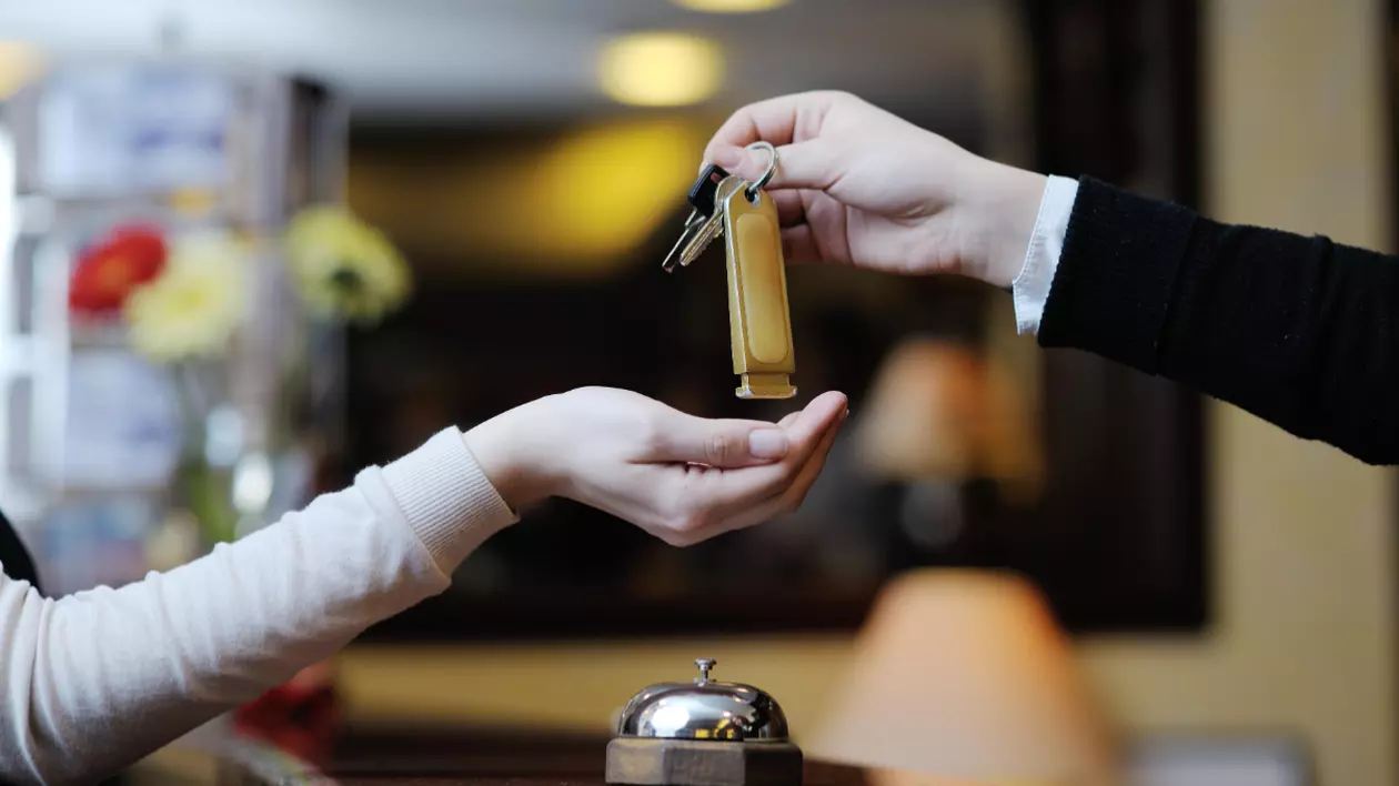 O recepționeră care predă cheia unei femei la hotel
