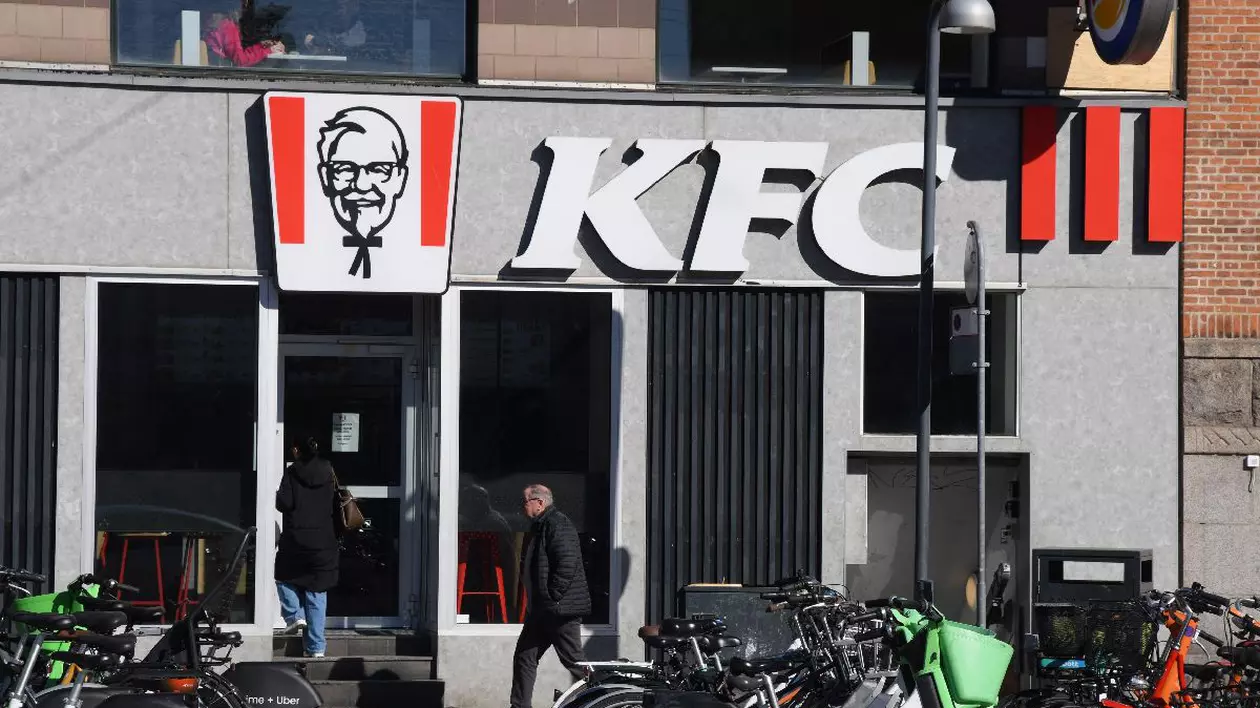 Fațada unui restaurant KFC din Copenhaga în fața căruia sunt parcate foarte multe biciclete.