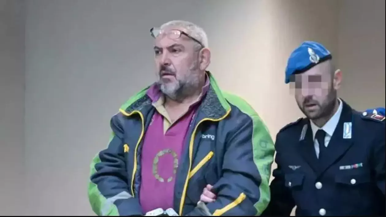 Șoferul român de TIR Vasile Teleptean, în geacă, acuzat de omor după accident rutier, a fost condamnat și este ținut de un polițist