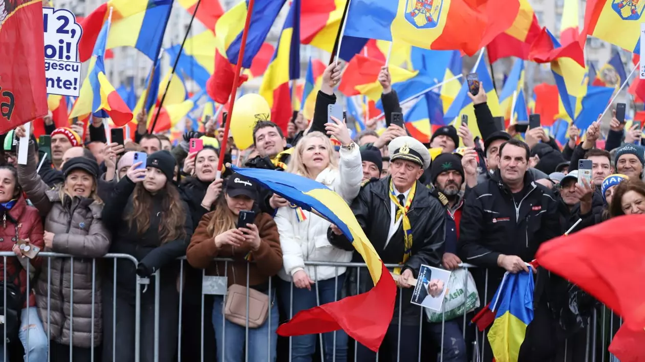 Oameni ieșiți în stradă și cate flutură drapelul României