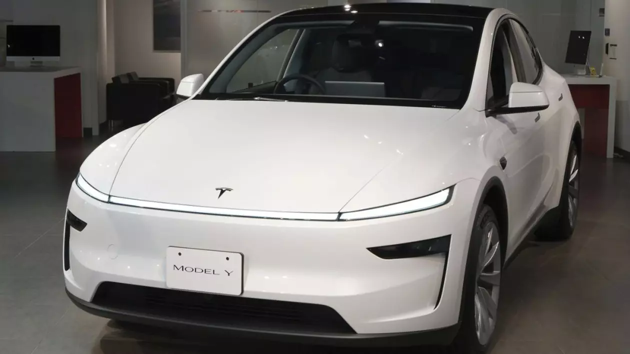 O mașină albă Tesla, Model Y, expusă la un salon auto din Japonia
