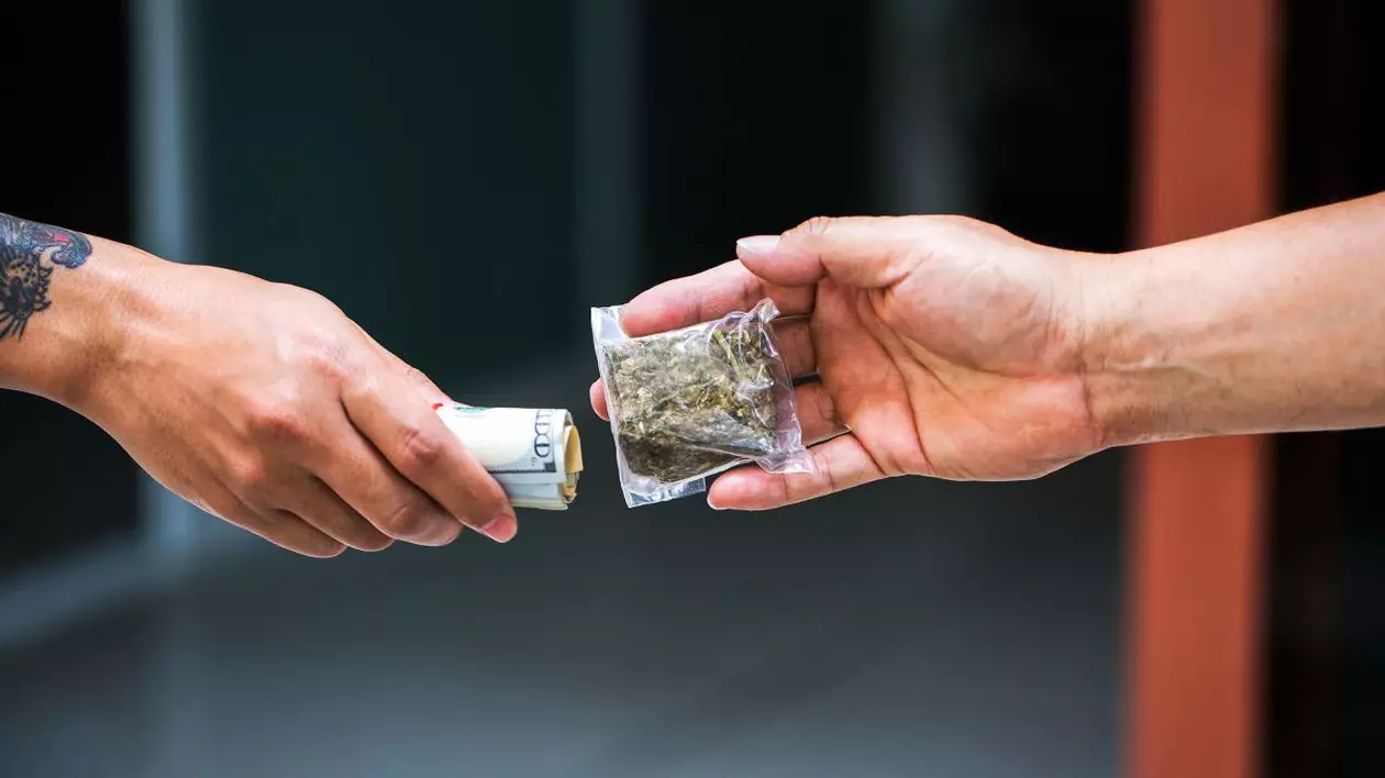 Imagine creativă cu doi bărbați, unul care vinde droguri, iar altul care cumpără și îi oferă bani celuilalt