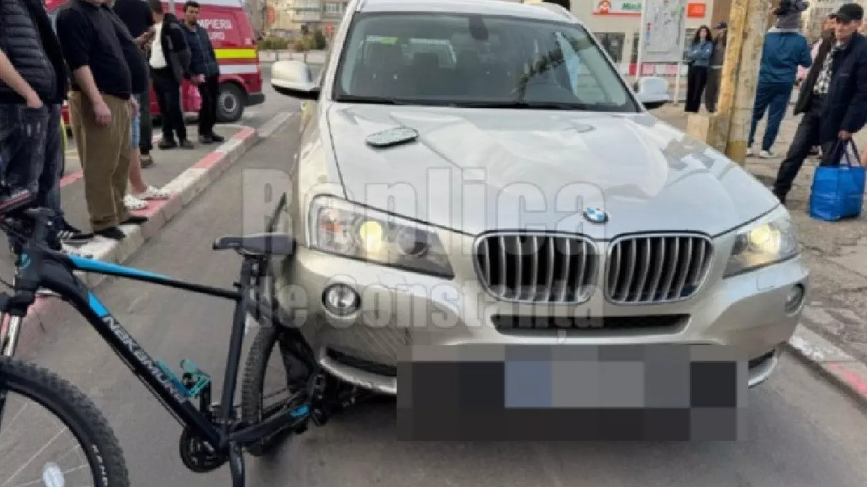 O mașina BMW argintie care a lovit o bicicletă