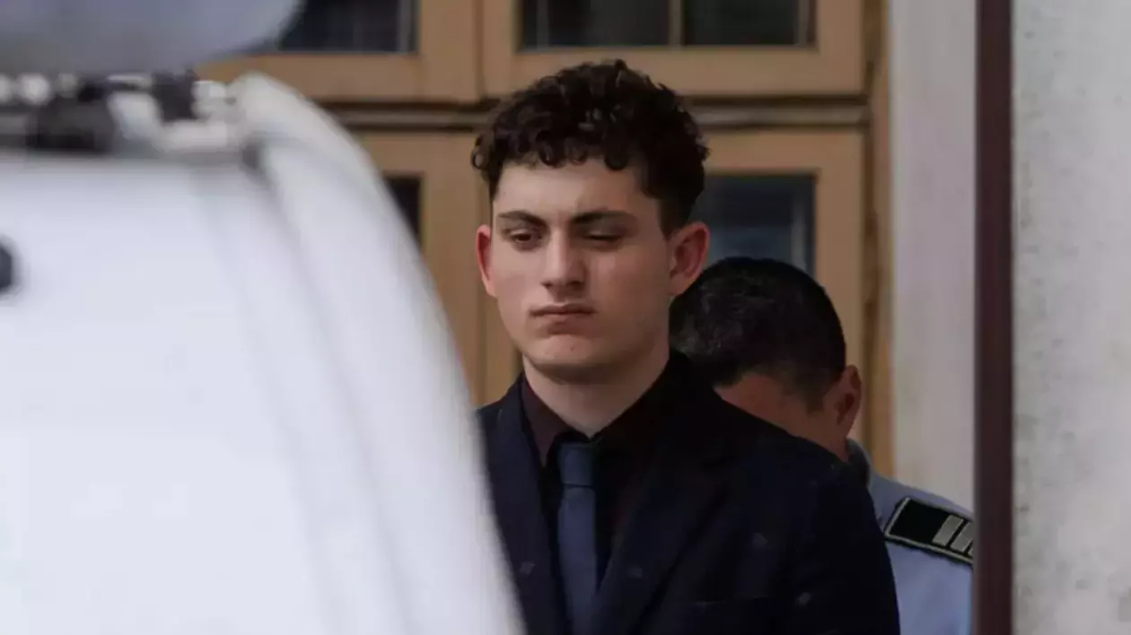 Vlad Pascu, îmbrăcat într-un costum negru, cu o cămașă și cravată închise la culoare