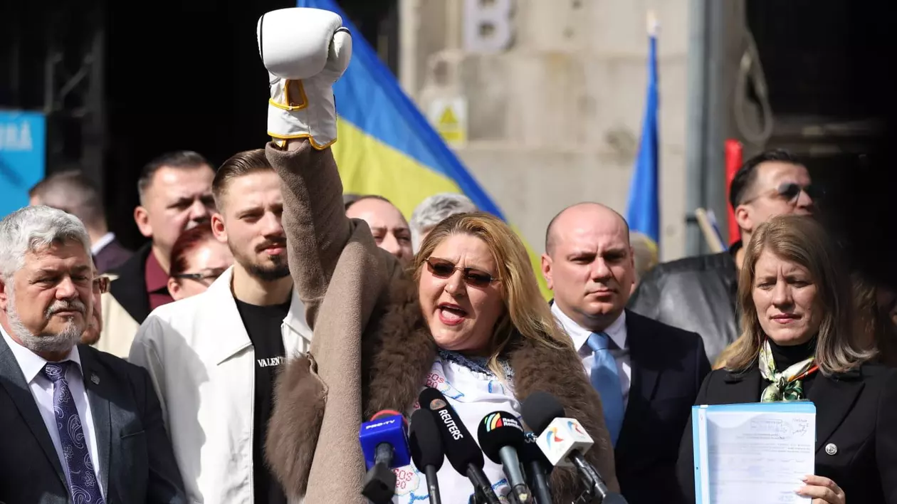 O femeie cu mâna dreaptă ridicată în sus, cu o mănușă de box pe mână