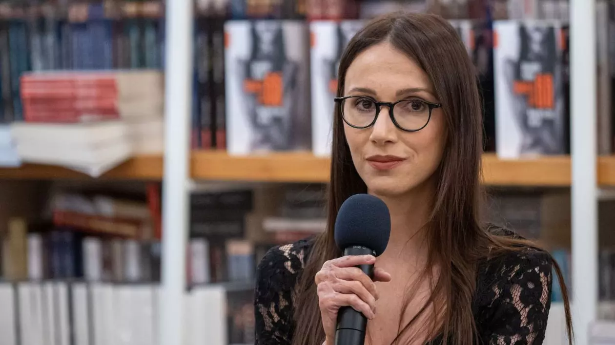 Alexandra Furnea la lansarea cărții sale, „Jurnalul lui 66”, ținând un microfon în mână